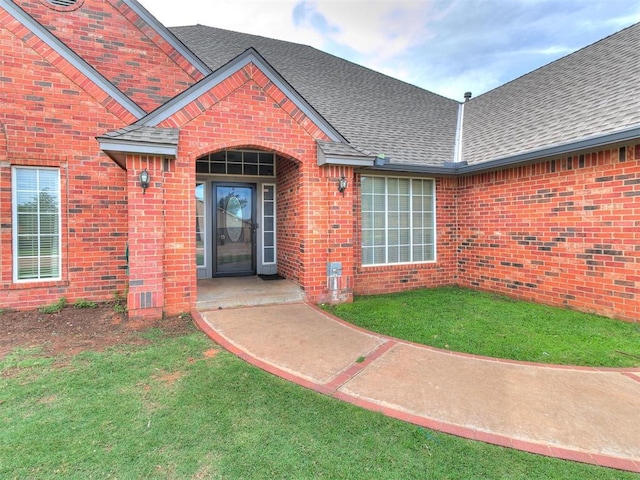 view of exterior entry featuring a yard