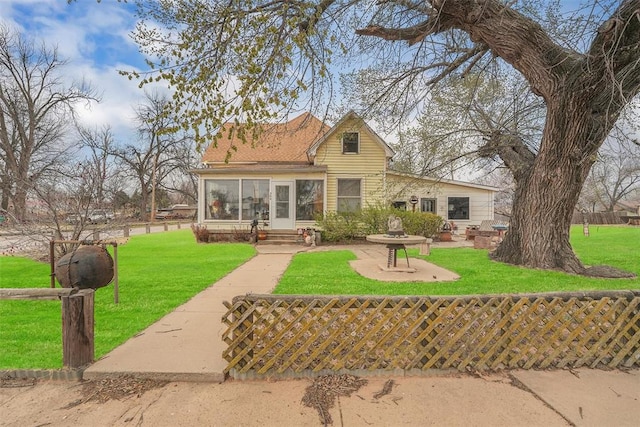 view of front of home featuring a sunroom and a front lawn