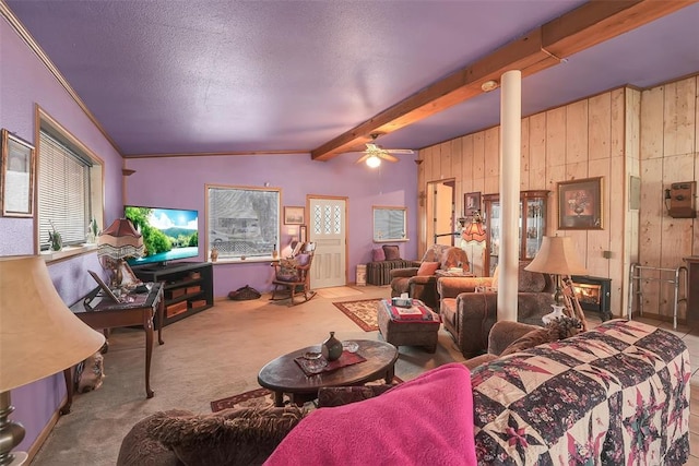 carpeted living room with a textured ceiling, ceiling fan, wooden walls, lofted ceiling with beams, and a wood stove