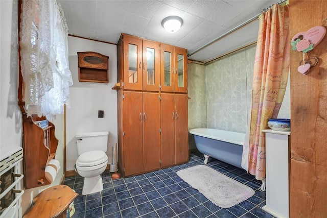 bathroom featuring tile patterned floors, a bath, and toilet