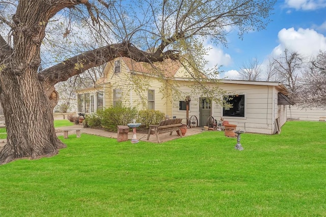 rear view of house featuring a yard and a patio