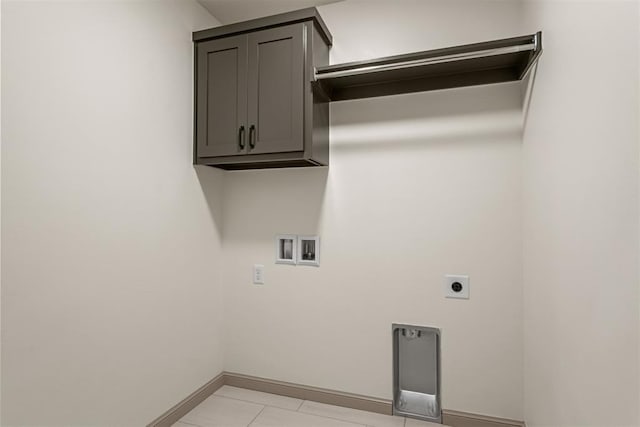 washroom featuring hookup for an electric dryer, hookup for a washing machine, and cabinets