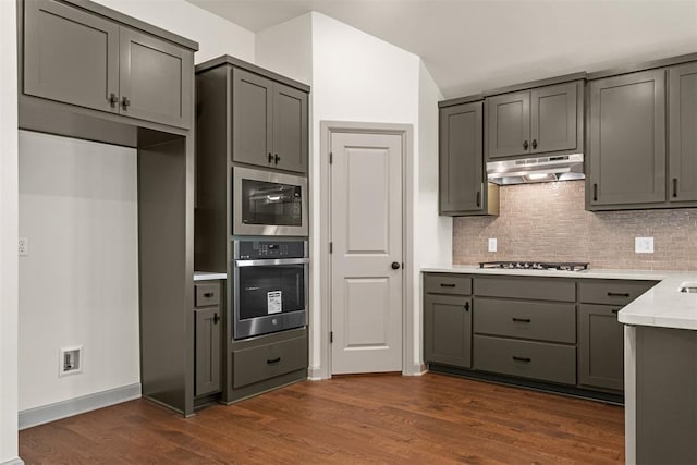 kitchen with backsplash, gray cabinets, dark hardwood / wood-style flooring, and appliances with stainless steel finishes