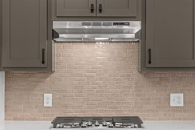 kitchen featuring backsplash, gray cabinets, stainless steel gas cooktop, and exhaust hood