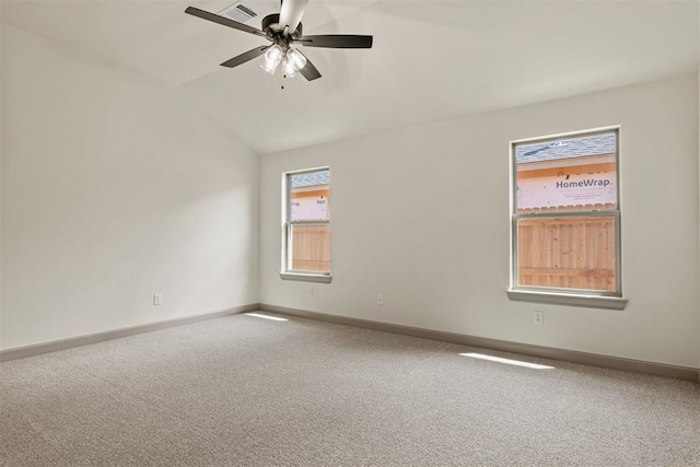 carpeted spare room with ceiling fan and vaulted ceiling