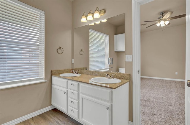 bathroom featuring vanity, a wealth of natural light, hardwood / wood-style floors, and ceiling fan