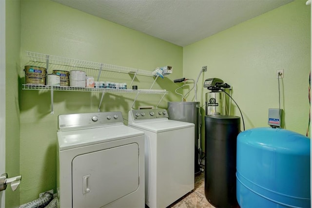 washroom with washer and clothes dryer and a textured ceiling