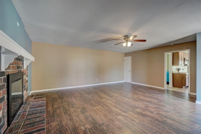 unfurnished living room featuring ceiling fan, dark hardwood / wood-style flooring, and a fireplace