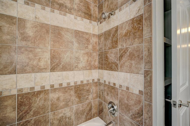 interior details with tiled shower / bath combo