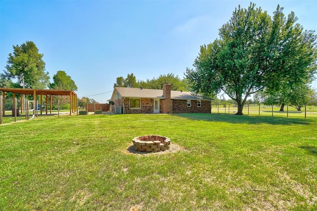 view of yard with a fire pit and central air condition unit