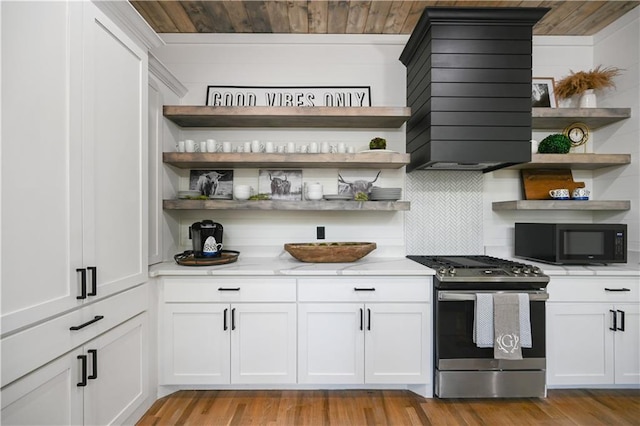 interior space with white cabinets, gas stove, wood ceiling, and light hardwood / wood-style flooring