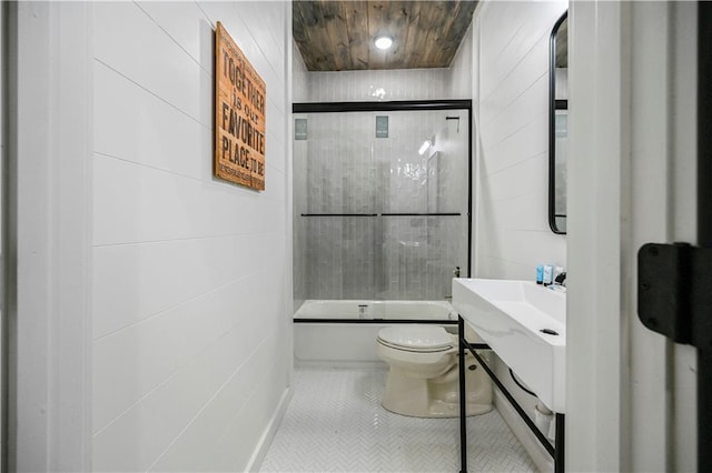 bathroom with bath / shower combo with glass door and toilet