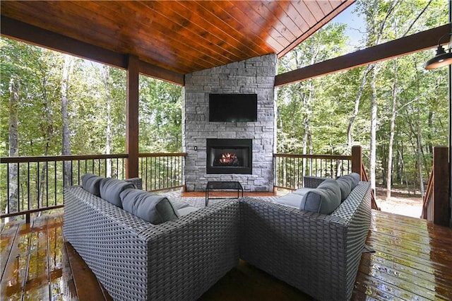 wooden deck with an outdoor living space with a fireplace