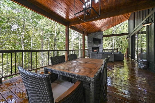 wooden terrace with an outdoor living space with a fireplace