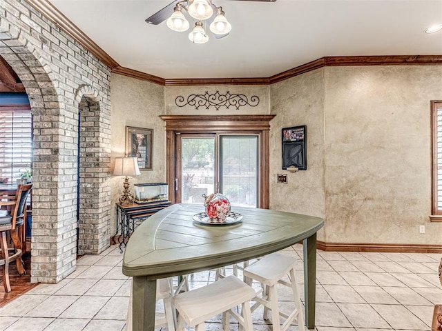 tiled dining room featuring ceiling fan and ornamental molding