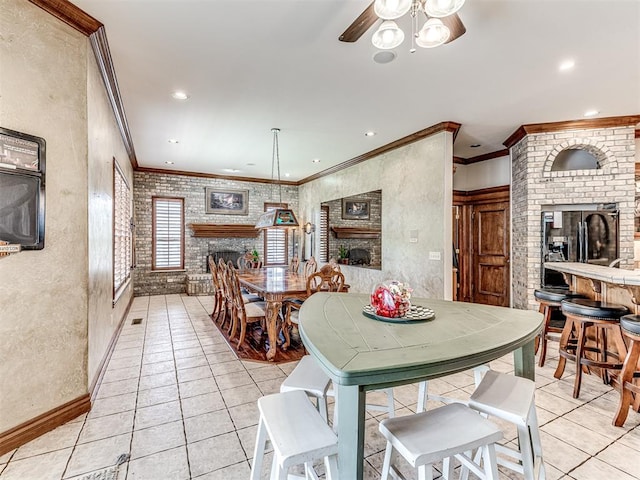 tiled dining area featuring ceiling fan, a fireplace, brick wall, and ornamental molding