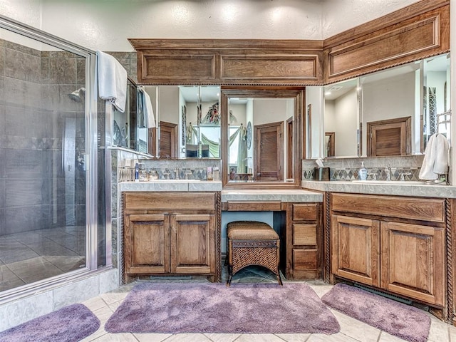 bathroom with vanity, tasteful backsplash, tile patterned floors, and a shower with shower door