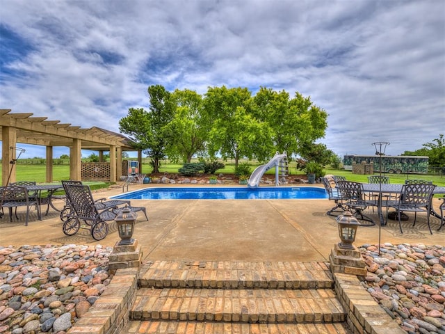 view of pool with a pergola, a patio area, and a water slide