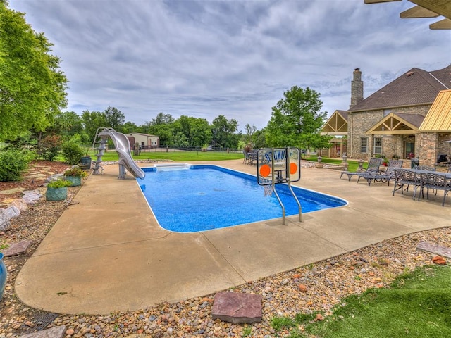 view of pool featuring a patio area and a water slide