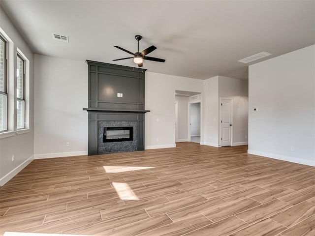 unfurnished living room featuring light wood-type flooring and ceiling fan