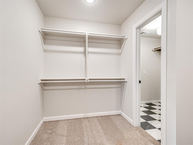 walk in closet with light colored carpet