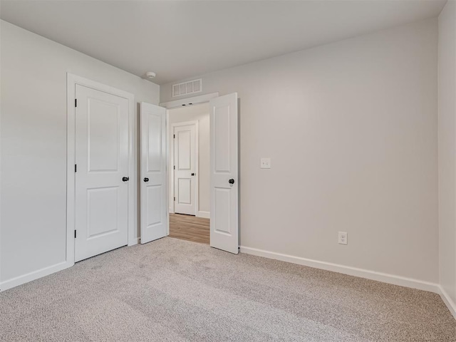 unfurnished bedroom featuring light colored carpet