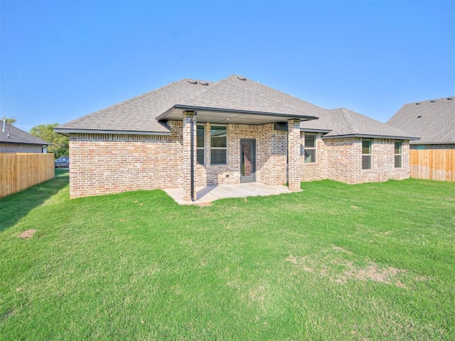 back of house with a lawn and a patio area