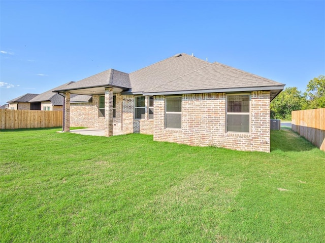 rear view of house featuring a yard, a patio, and central air condition unit