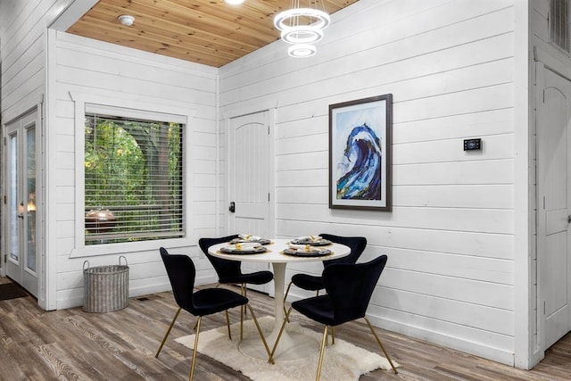 dining space featuring breakfast area, hardwood / wood-style floors, an inviting chandelier, and wood ceiling