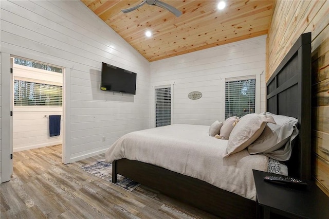 bedroom with hardwood / wood-style flooring, lofted ceiling, ensuite bath, wood ceiling, and wood walls