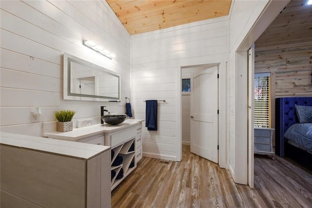 bathroom with lofted ceiling, wood-type flooring, vanity, wooden ceiling, and wooden walls