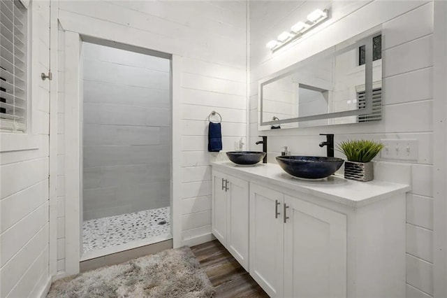 bathroom featuring hardwood / wood-style flooring, vanity, and tiled shower