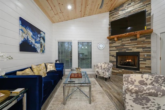 living room with a fireplace, lofted ceiling, wood ceiling, wood walls, and hardwood / wood-style floors