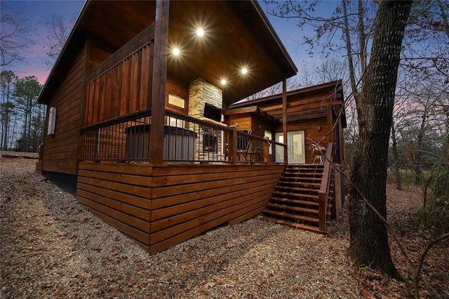 property exterior at dusk featuring a wooden deck