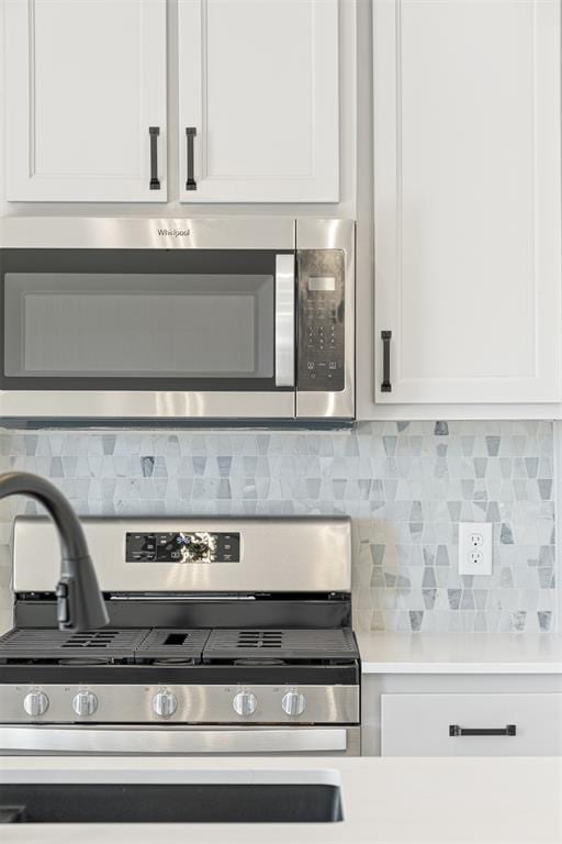 kitchen featuring white cabinets, backsplash, and stainless steel appliances