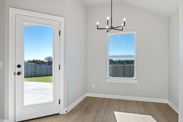 unfurnished dining area with light hardwood / wood-style floors, an inviting chandelier, and a healthy amount of sunlight