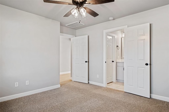 unfurnished bedroom featuring light carpet, connected bathroom, and ceiling fan