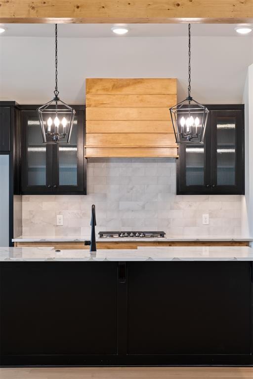 kitchen with tasteful backsplash, hanging light fixtures, and stainless steel gas stovetop