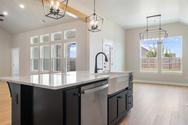 kitchen featuring light stone countertops, hanging light fixtures, stainless steel dishwasher, light hardwood / wood-style floors, and a kitchen island with sink