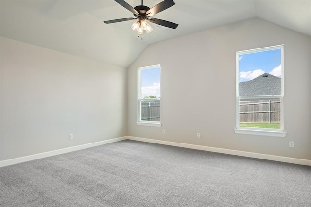 empty room with carpet flooring, a wealth of natural light, and vaulted ceiling