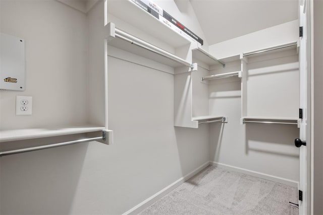 spacious closet featuring light carpet and vaulted ceiling