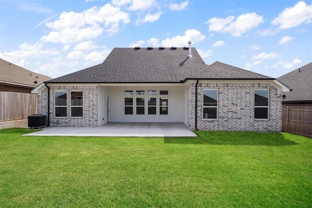 rear view of property featuring a lawn, a patio area, and central AC