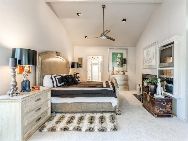 bedroom featuring ceiling fan, light colored carpet, and vaulted ceiling