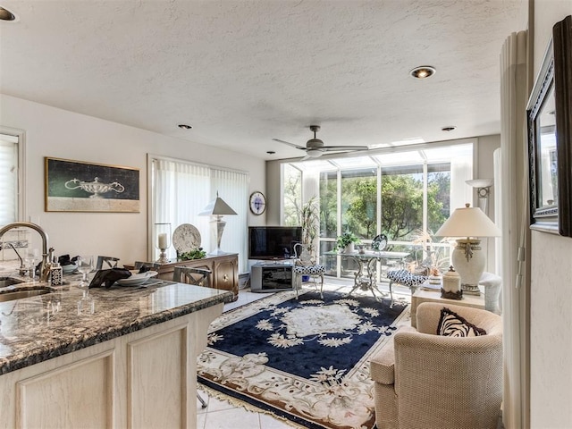 living room featuring a textured ceiling, a wealth of natural light, and sink