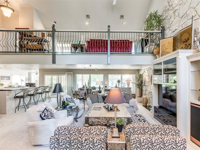 carpeted living room featuring a towering ceiling