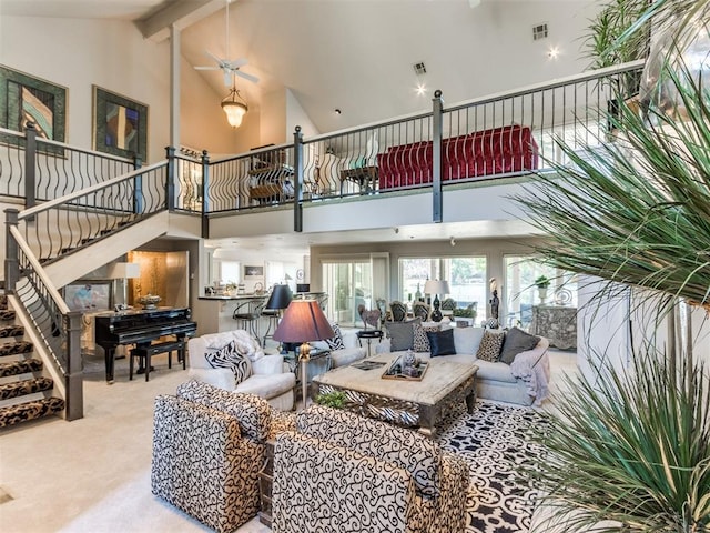 living room with carpet flooring, ceiling fan, beamed ceiling, and high vaulted ceiling