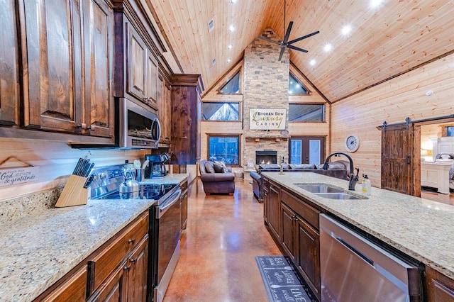 kitchen with stainless steel appliances, a barn door, sink, wooden ceiling, and high vaulted ceiling