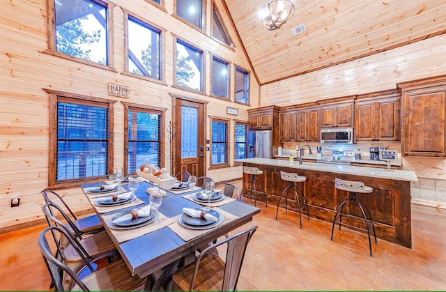 dining space with high vaulted ceiling, wooden walls, and wood ceiling