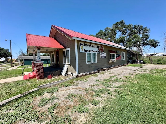 view of side of property featuring a lawn and a porch