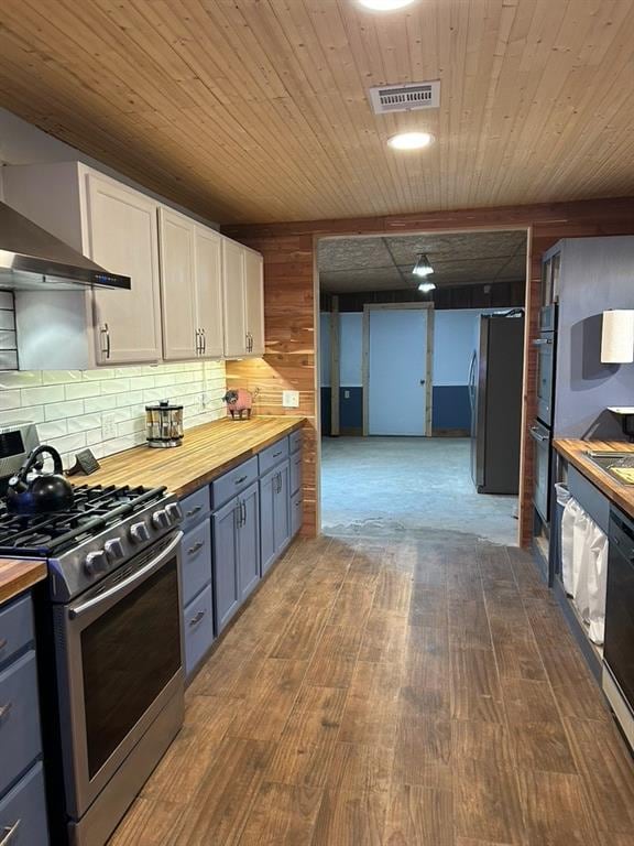 kitchen with wooden counters, wood-type flooring, white cabinets, and black appliances